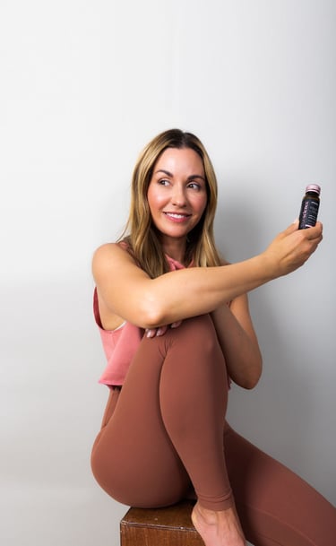 TrueScience liquid Collagne bottle being held by a woman sitting | Biohack Health now