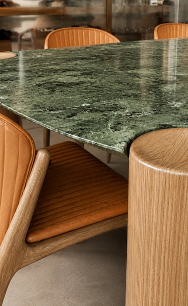 Detalhe de interiores no Leblon com mesa em pedra verde e marcenaria autoral
