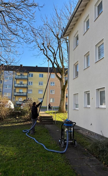 a man is using a hose to clean a lawn
