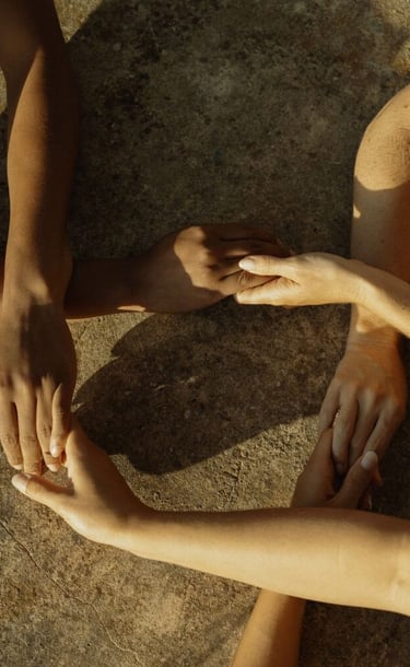 des personnes se tiennent les mains dans la nature au couché du soleil