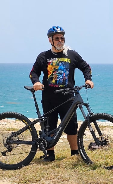 a man standing next to a sign at El Faro,  Cabo Rojo