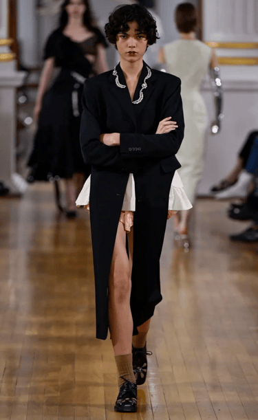 Simone Rocha model in black tailored coat dress on the runway at London Fashion Week 2026.