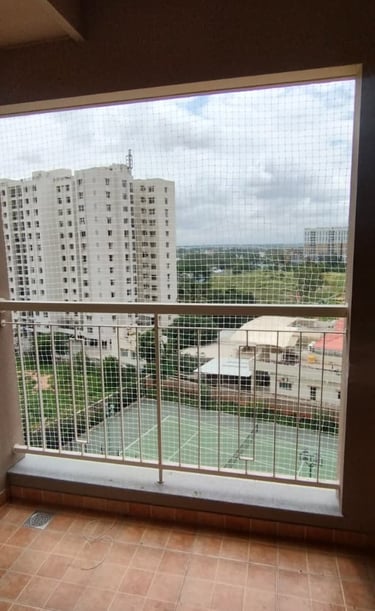 Wide shot showing a building facade fully covered with anti-pigeon nets by Arjilli Enterprises.