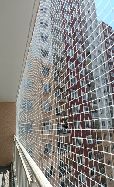 Wide shot of a high-rise building balcony secured with tight, durable pigeon netting