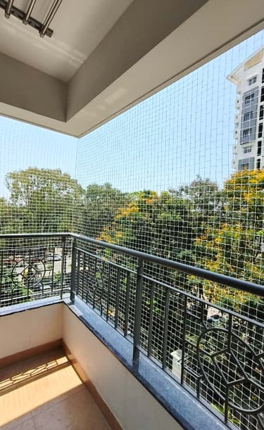 Wide shot showing a balcony fully covered with a safety net against a clear blue sky.