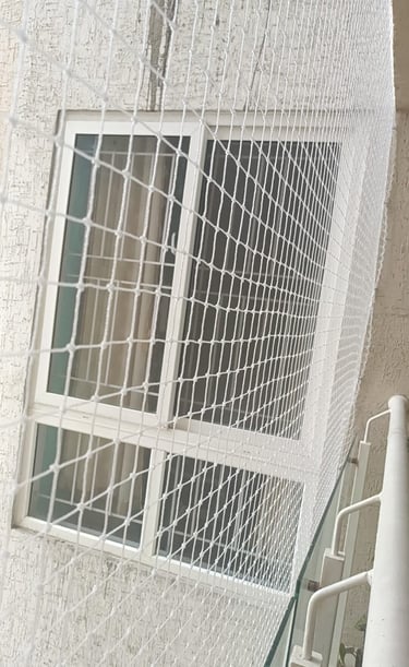 Wide shot showing a full balcony covered with tightly stretched pigeon netting.