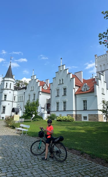 Karolina na rowerze przed białym pałacem. Rodzinna multiagencja ubezpieczeniowa Wrocław.