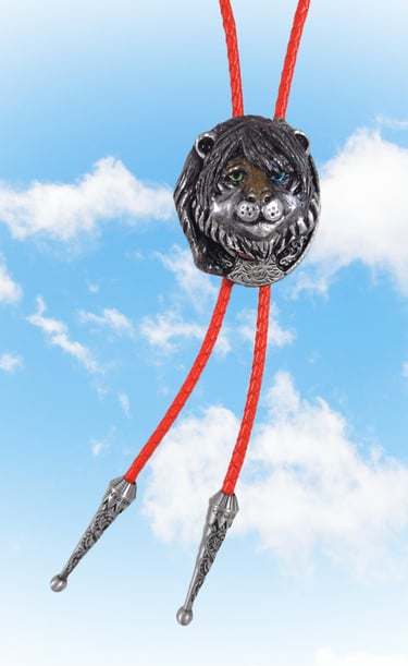 Vintage silver lion head bolo tie with orange braided cord against a blue sky background.