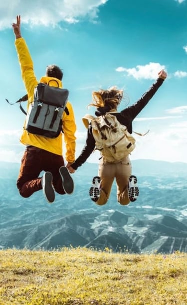two people jumping in the air with their hands up in the air