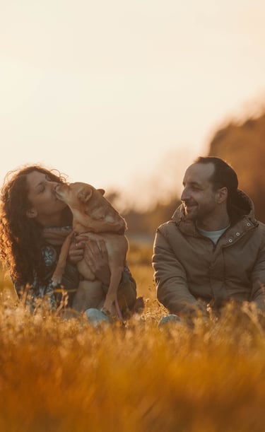 ritratto di un uomo e una donna con il cane in braccio al tramonto
