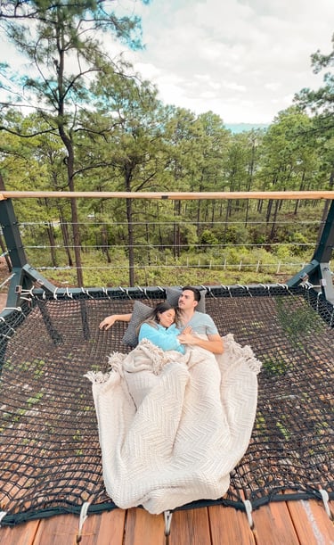 a man and woman sitting in a hammock