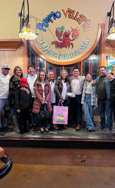 A group of friends smiling together at Puerto Vallarta Mexican restaurant for a birthday celebration.