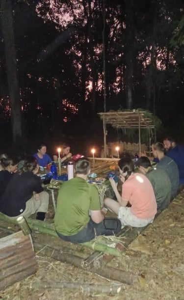 a group of people sitting around a table with candles