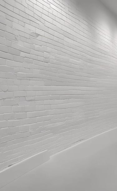 Building exterior mid-clean, with grime washing away to reveal fresh brickwork under a clear blue sky.