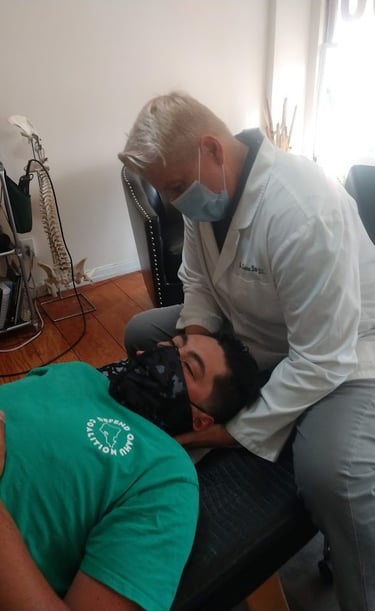 Dr. Lonna Denny performing a traditional neck adjustment to a patient.