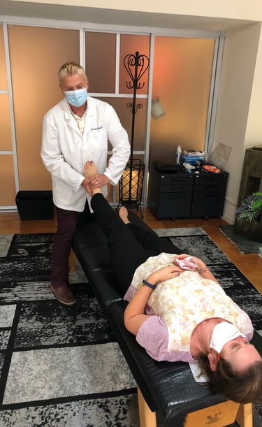 Dr. Lonna Denny performing a leg adjustment to her female patient.