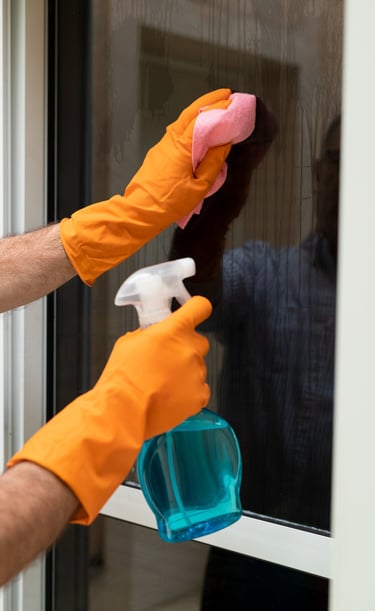 a man cleaning a window with a spray bottle