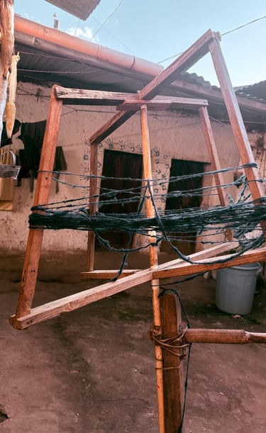  Bobinadora de hilo de madera tradicional que hila hilo de lana oscura en un entorno de patio