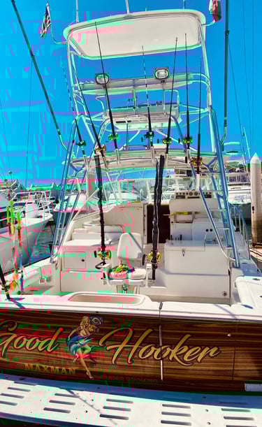 Charter fishing boat in a marina with fishing rods, a fighting chair, and custom woodwork.