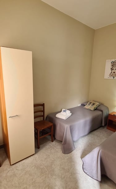 a bedroom with two beds and a chair