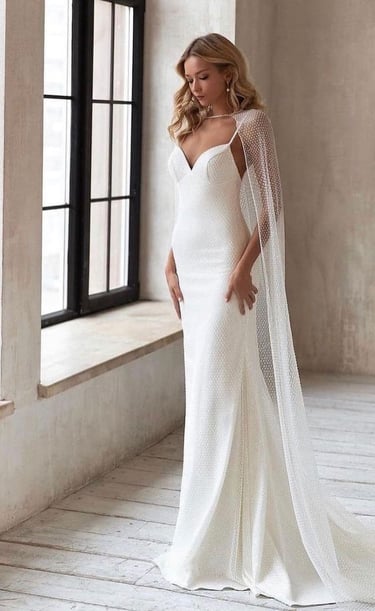 belle mariée portant une robe fluide avec une cape