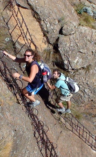 two backpackers climbing a chain ladder in South Africa