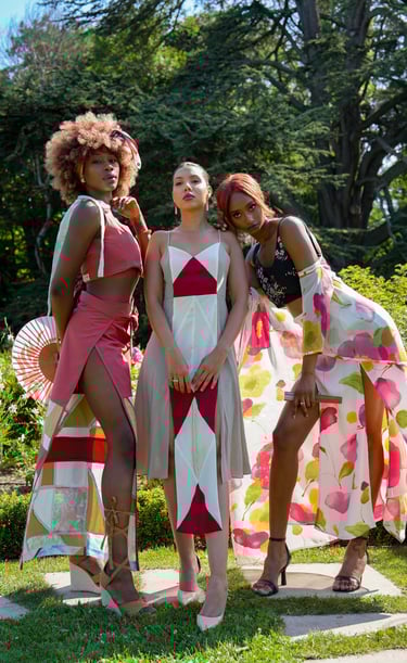 three women models standing in front of a tree