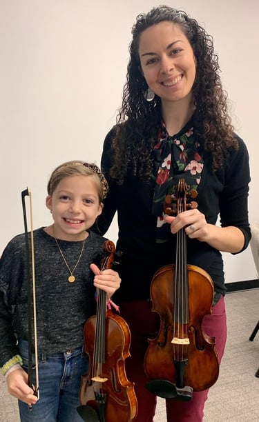 Child taking violin lesson