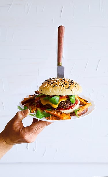 a person holding a plate with a hamburger burger on it