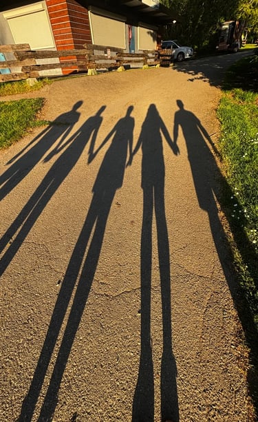 Familia tomada de la mano frente a su hogar, símbolo de herencias y sucesiones