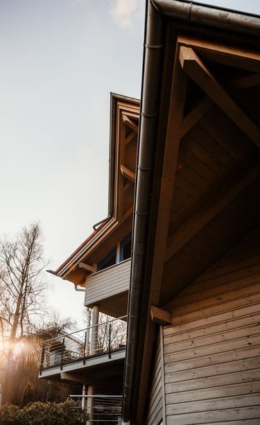 a house with a large wooden deck and a balcony with a view of the sun