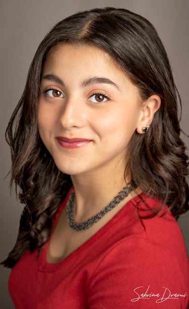 a girl in a red shirt and necklaces