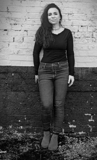 Black and white portrait of Helen Spooner, pianist and vocalist, standing against a brick wall.