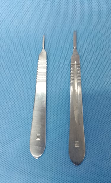 Dois cabos de bisturi (modelos 3 e 4) sobre tecido azul estéril, compatíveis com lâminas cirúrgicas