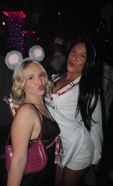 Two women in mouse ears and Flo from Progressive costumes posing for a Halloween party photo.