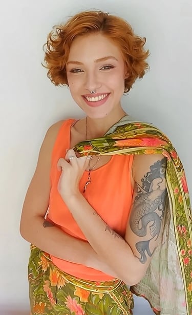 Sabrina Tibursky sorrindo carregando em uma mão um casaco sobre os ombros