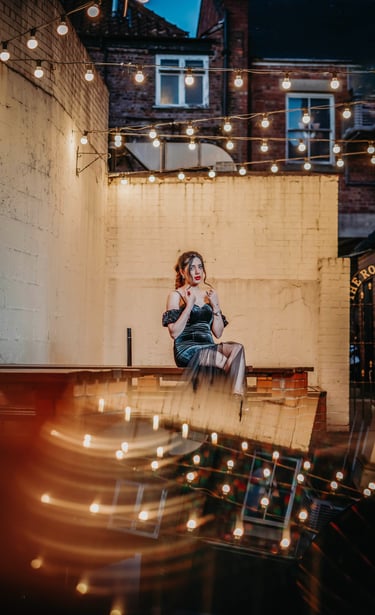 Bride posing under string lights in a York courtyard, captured by Fred Art Studio.