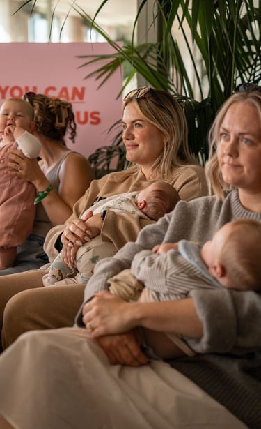 photo of women holding their babies in the arms and smiling 