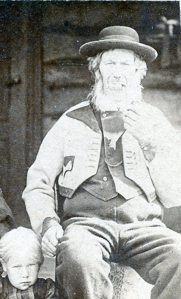 A black and white image of a man and a child in tradtitional costume