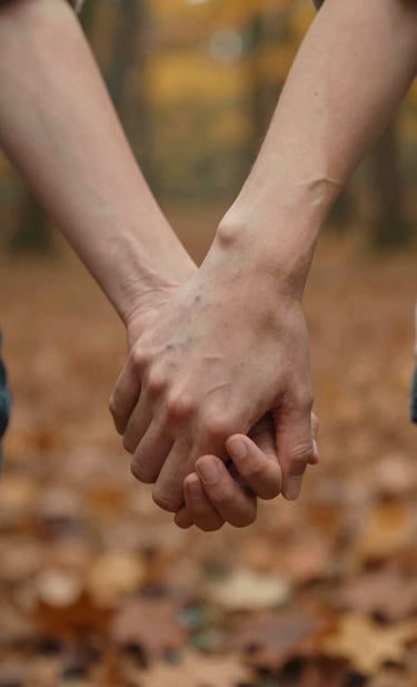 A close-up, cinematic shot of two hands gently holding each other, symbolizing connection. The background is a blurred, warm autumn forest with hints of terracotta leaves. The lighting is soft and golden, emphasizing a personal and authentic touch.