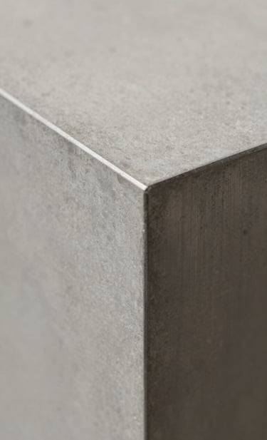 A detail-oriented close-up of high-quality architectural materials. A combination of smooth concrete and brushed #2F2E2E steel panels. The shot focuses on the precision of the joints and the play of soft shadows on #D9D2C7 textures, conveying a sense of quality and confidence.