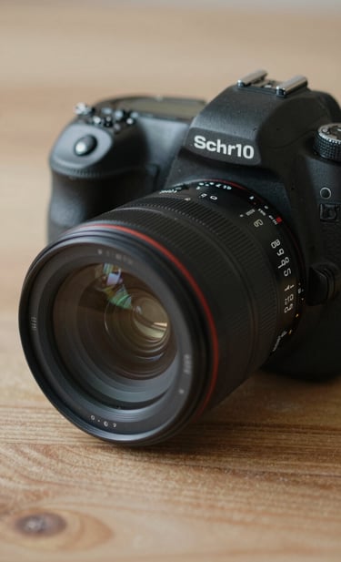 A professional DSLR camera placed on a textured wooden surface, capturing the photographer's gear in a storytelling style. Soft side-lighting emphasizes the lens glass. The mood is professional and ready for action, using a color palette of #0D0D0D and #8C847E.