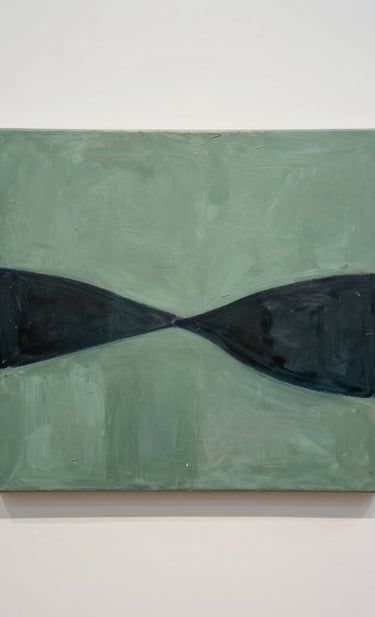 A minimalist gallery scene in a North American setting. On an off-white wall hangs a textured acrylic on canvas painting featuring sage green and dark charcoal abstract forms. The composition is clean and artistic, captured with professional gallery lighting.