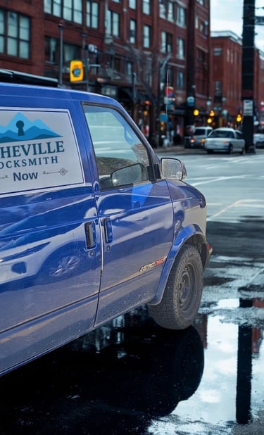 Blue Asheville Locksmith Now service van driving through West Asheville on rainy day