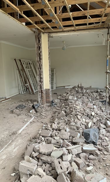 Mur intérieur démoli, gravats au sol et plafond ouvert – réaménagement complet d’un espace de vie