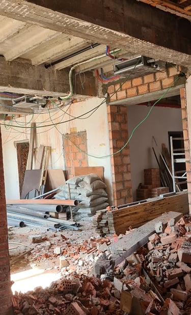 Travaux de démolition intérieure avec ouverture de mur porteur et évacuation des gravats en cours.