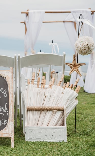off white paper hangers in box at beach wedding set up