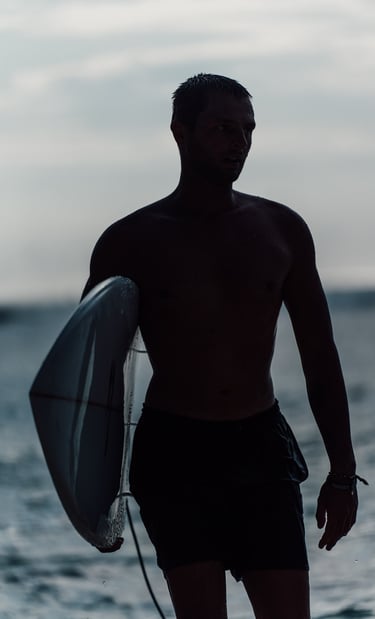 a man holding a surfboard while standing in the water