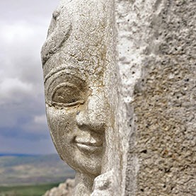 Close-up of an ancient stone sphinx head carving at the Sphinx Gate in Hattusa, Turkey.