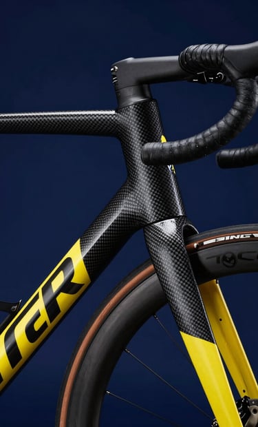 A close-up, high-detail shot of a high-end road bicycle frame with carbon fiber texture, featuring sleek yellow accents against a deep navy blue background. The lighting is dramatic and moody, emphasizing forward-thinking design and a passion for engineering and hobbyist precision.
